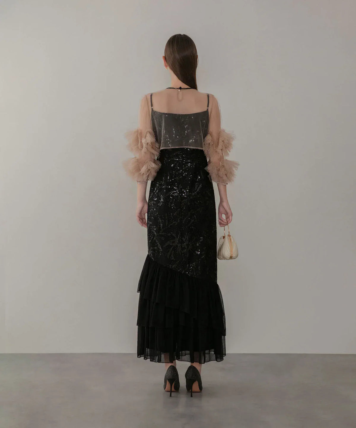 透け感のあるベージュのフリルスリーブと黒のスパンコールが華やかなロング丈オケージョンドレスの後ろ姿。