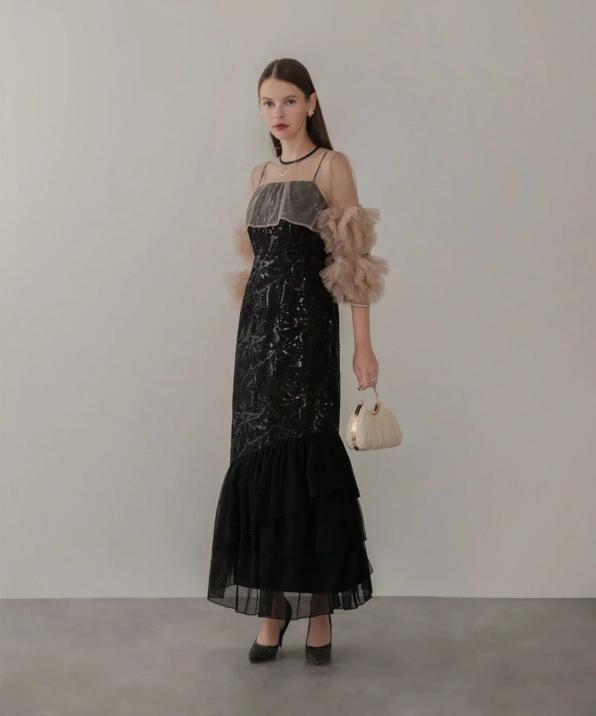 ベージュのチュールフリル袖と黒のスパンコール刺繍が華やかなマーメイドシルエットのロング丈ワンピース。