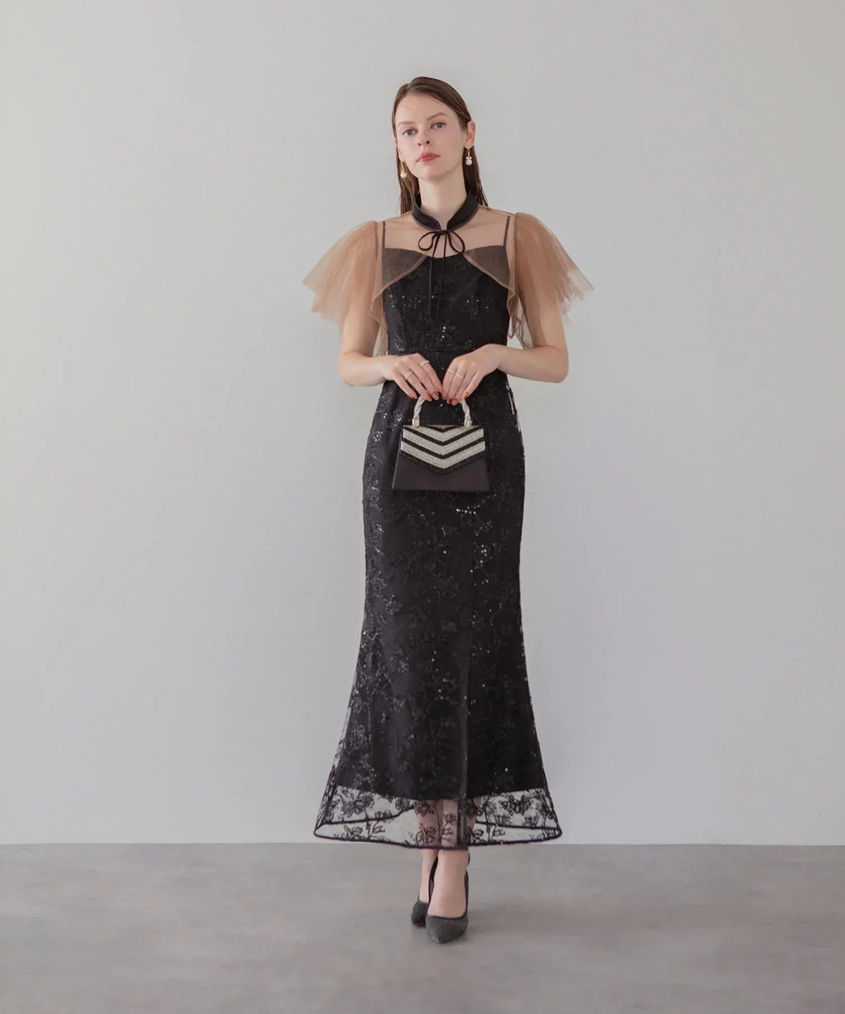 透け感のあるベージュのチュールボレロにスパンコール刺繍が華やかに輝く、結婚式のお呼ばれにおすすめな黒のロング丈マーメイドパーティードレス。
