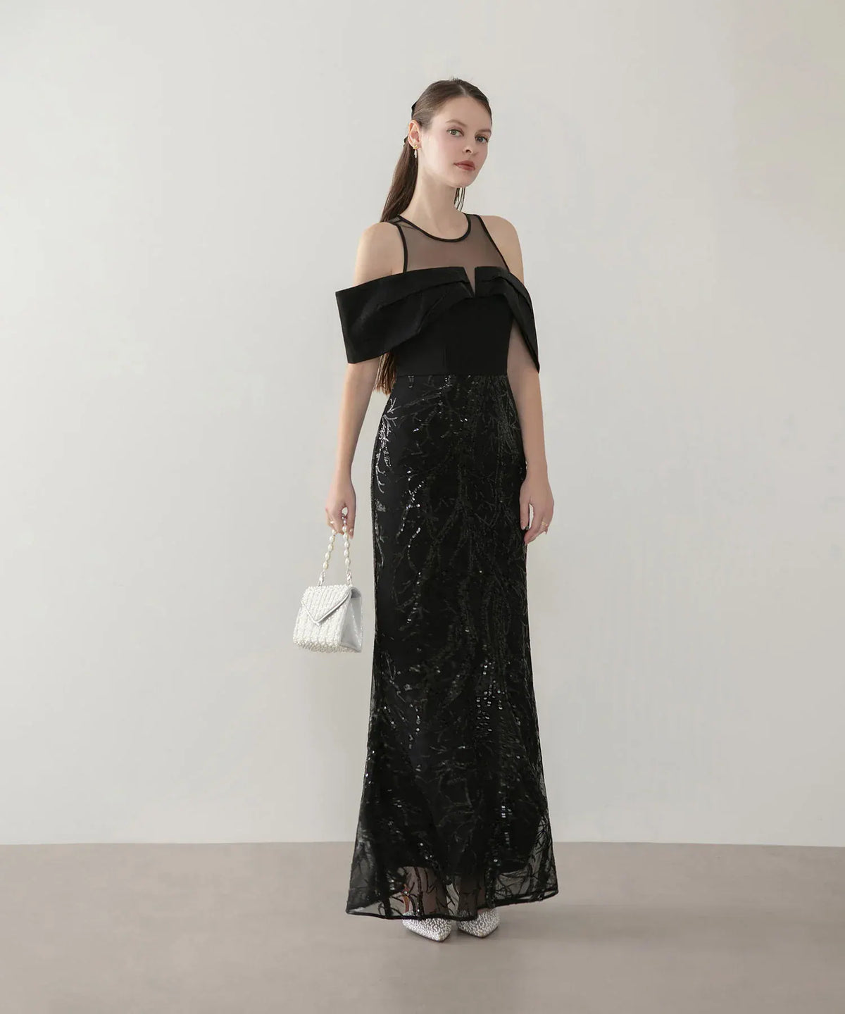 透け感のあるシースルーネックと黒のオフショルダードレープが上品な、スパンコール刺繍が輝く黒のマーメイドロングイブニングドレス。