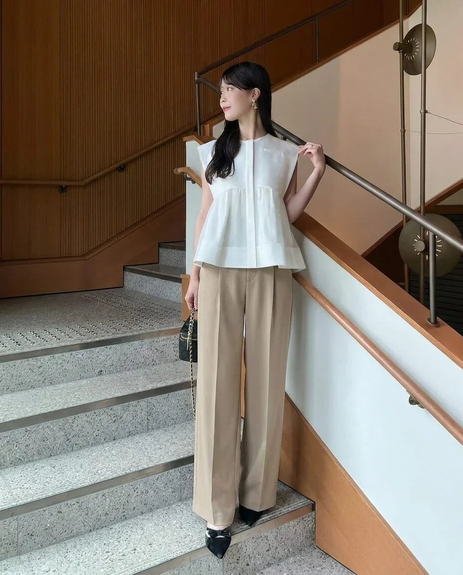 ベージュのワイドパンツと合わせた、白のノーカラーシアーオーガンジーフレアペプラムトップスの全身コーディネート。