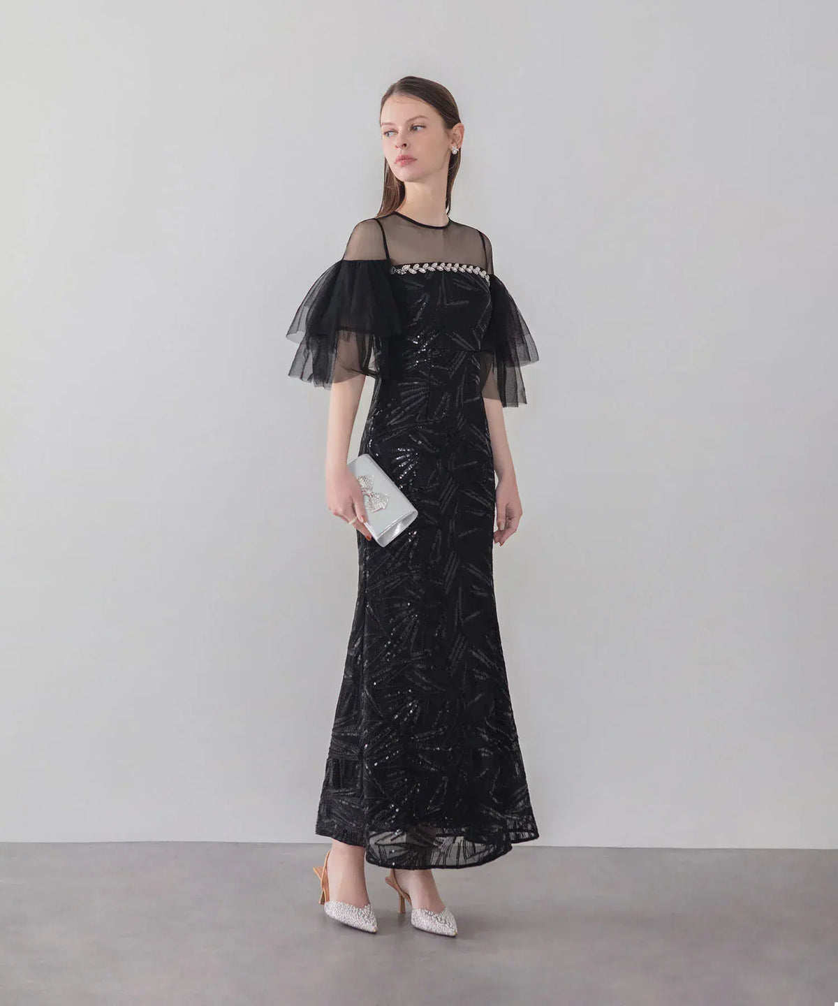 シアーなチュール袖とフロントビジューが華やかな、スパンコール刺繍入り黒のマーメイドイブニングドレスの全身。