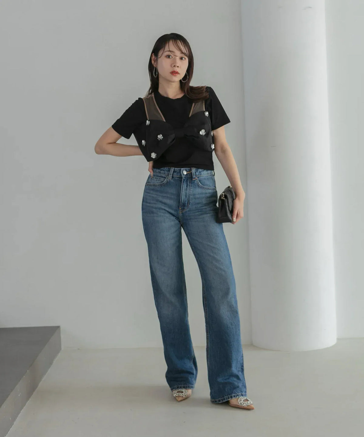 黒Tシャツにビジュー付きリボントップスを重ねデニムパンツと合わせた、ブラックの2WAYタイトドレスの着こなし例