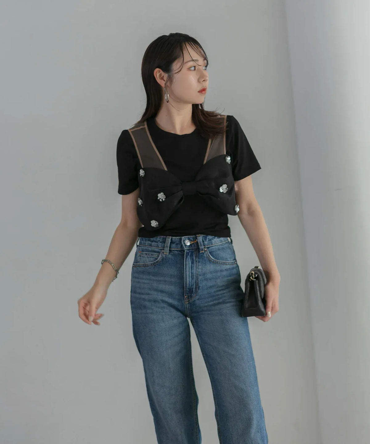 黒のTシャツとデニムにビジュー付きリボンモチーフをビスチェ風に重ね着した2WAYフラワーオフショルダースリットドレスのアレンジコーデ