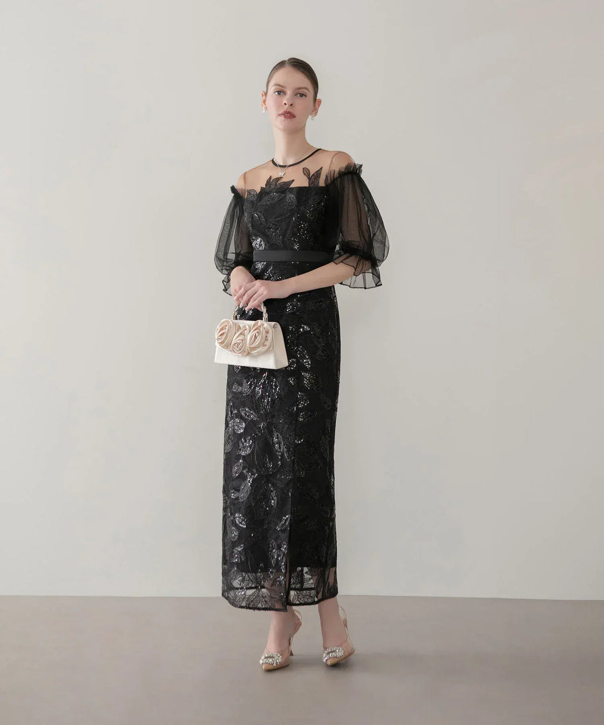 透け感のある黒チュール袖とリーフ柄スパンコールが華やかな、結婚式のお呼ばれにも着られるブラックのIラインパーティードレス。