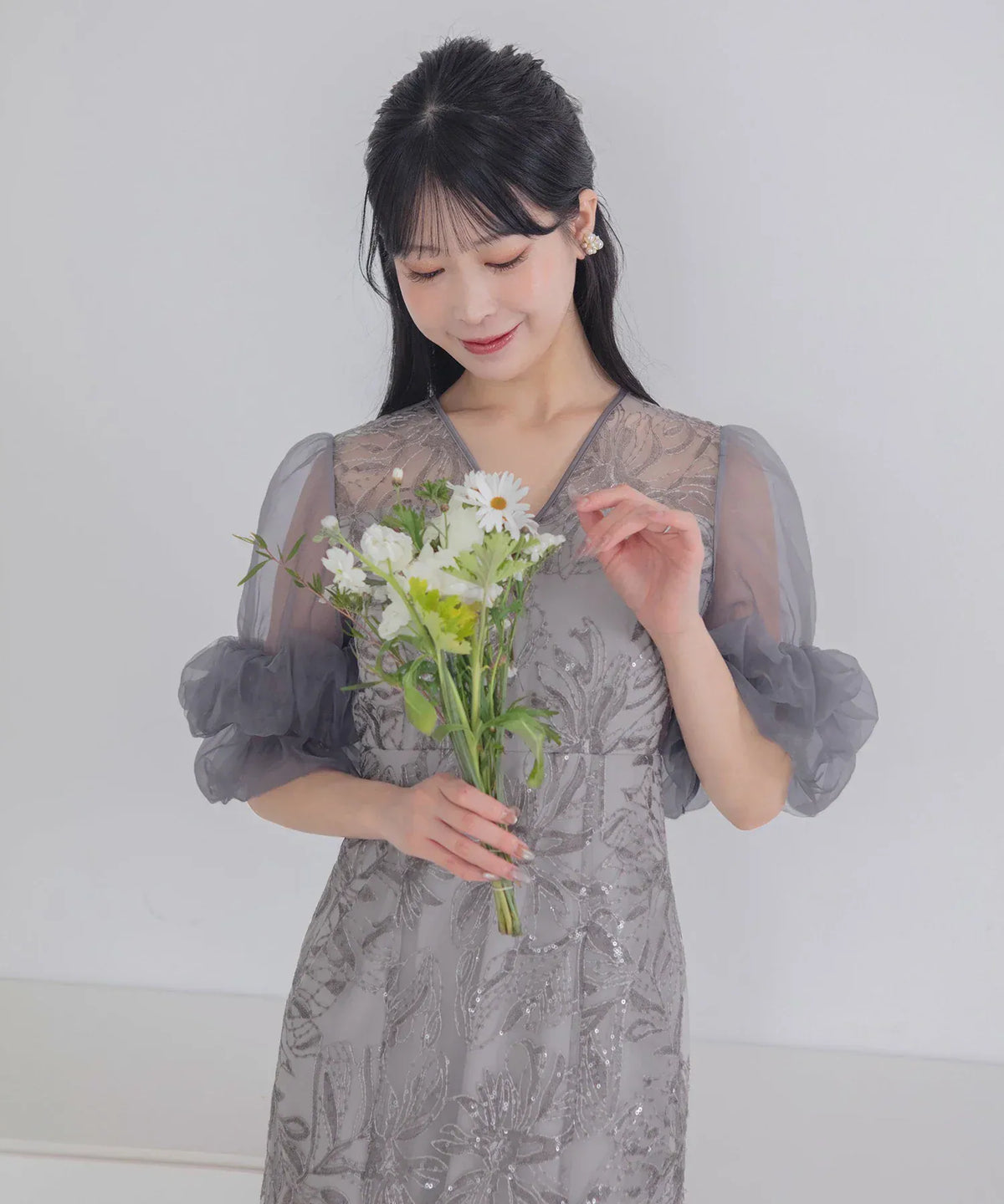 シアーなオーガンジーボリューム袖と華やかなフラワースパンコール刺繍が引き立つグレーのVネックIラインオケージョンドレス。