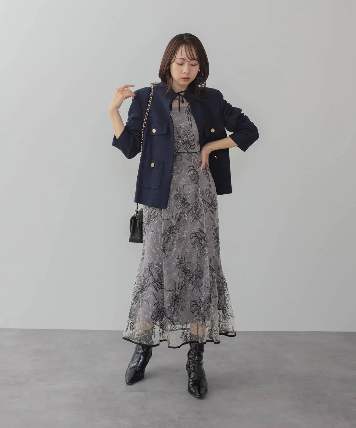 ネイビーのジャケットを羽織りブーツを合わせた、花柄チュール刺繍マーメイドワンピースの着こなし。